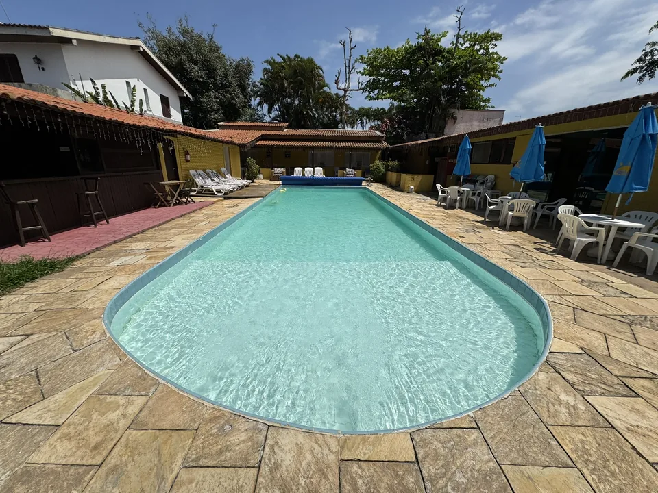 Piscina climatizada com guarda-sóis da Pousada Point Beach Jambolões